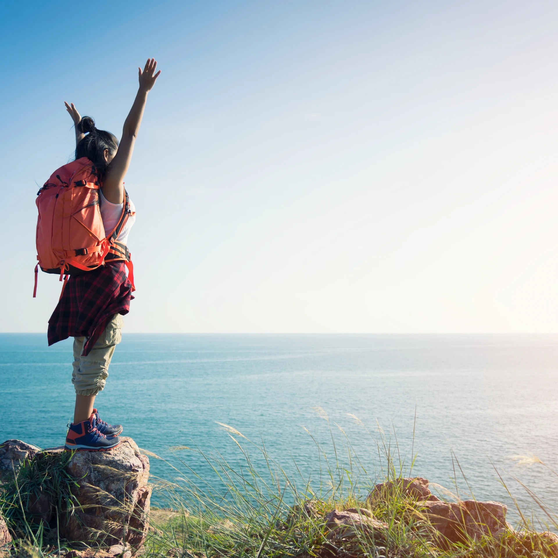Confident Traveler Standing on Rock near Ocean